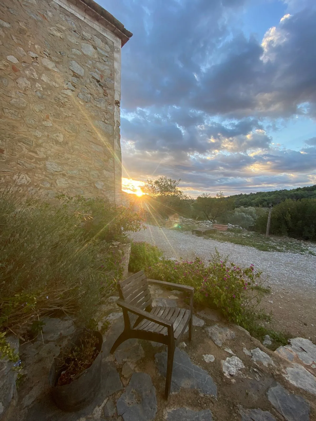 Fauteuil en bois près d’une bâtisse en pierre au coucher du soleil